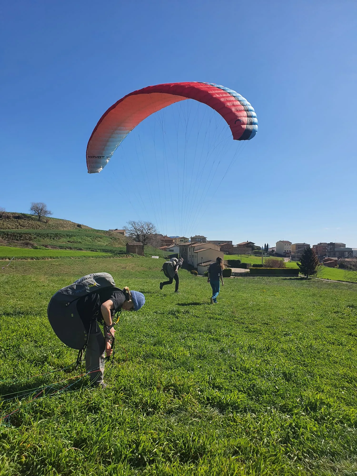 Alumnos preparándose en el campo mientras se infla una vela roja en el cielo