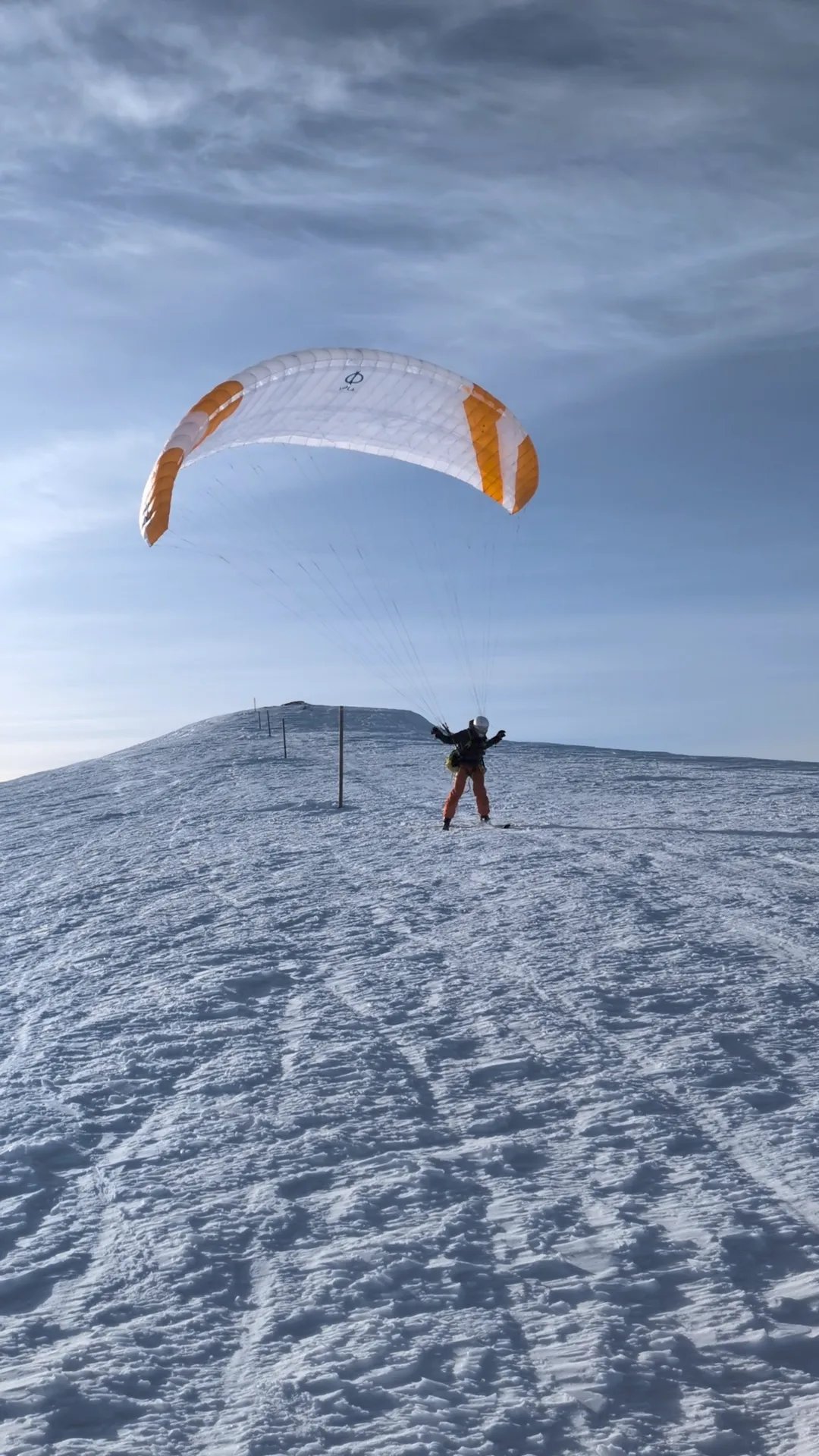 Despegue con esquís desde la cima del Puigllançada, la vela inflada sobre el piloto