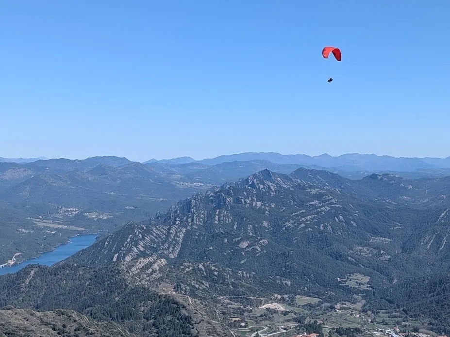 Parapente volando alto sobre Berga, con la ciudad y el pantano a los pies