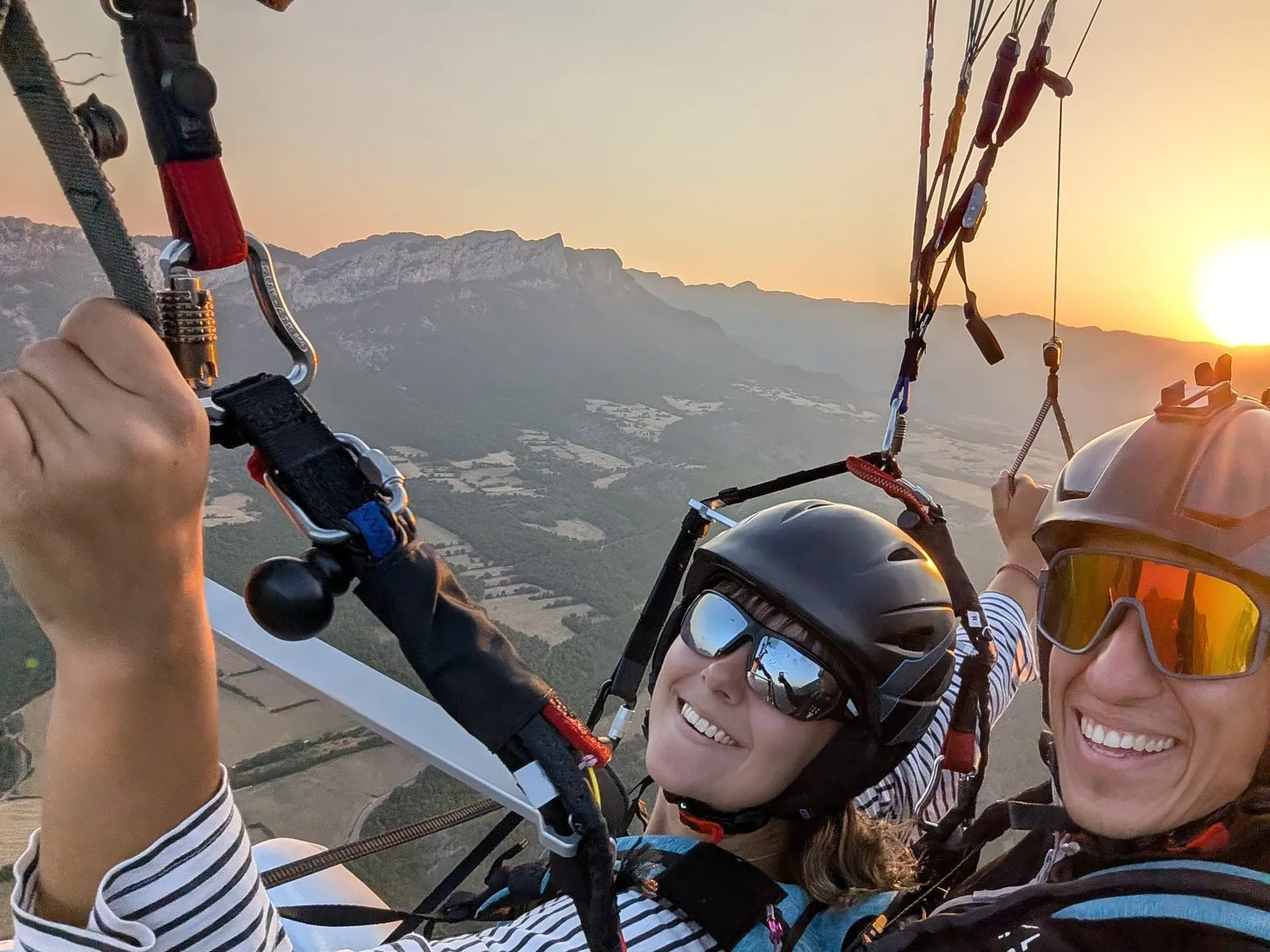 Alumna e instructor sonrientes en vuelo biplaza al atardecer